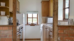 A compact kitchen with a washing machine, a microwave, and a sink. - 2 bedroom accommodation in Wadhurst, near Tunbridge Wells (Wadhurst, near Tunbridge Wells)