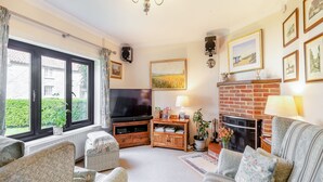 A cozy living room with a television, fireplace, and comfortable seating. - 3 bedroom accommodation in Ringstead, near Hunstanton (Ringstead, near Hunstanton)