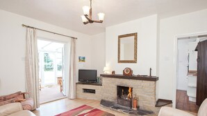 A living room with a fireplace, a television, and a sofa. - 4 bedroom accommodation in Chatcull, near Eccleshall (Chatcull, near Eccleshall)