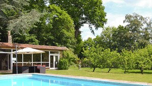 A swimming pool with a covered patio area, surrounded by lush greenery and trees. - 3 bedroom accommodation in Little Chart, near Ashford (Little Chart, near Ashford)