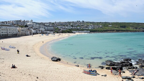 A coastal town with a sandy beach, clear turquoise waters, and buildings along the shore. - 2 bedroom accommodation in Lelant, near St Ives (Lelant, near St Ives)