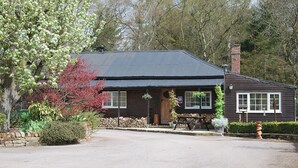 A rustic wooden building with a sloped roof, a stone wall, and a wooden door. - 2 bedroom accommodation in Brampton, nr Appleby (Brampton, nr Appleby)
