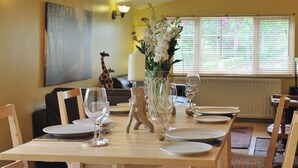 A dining table set for four with chairs, a vase with flowers, and a giraffe figurine on the wall. - 2 bedroom accommodation in Brampton, nr Appleby (Brampton, nr Appleby)