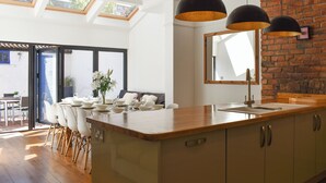 Una cocina moderna con una isla grande, tragaluces y una pared de ladrillo decorativa.