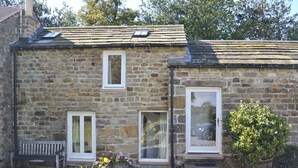 A stone building with two windows, a door, and a bench in the foreground. - 1 bedroom accommodation in Laverton, near Ripon (Laverton, near Ripon)