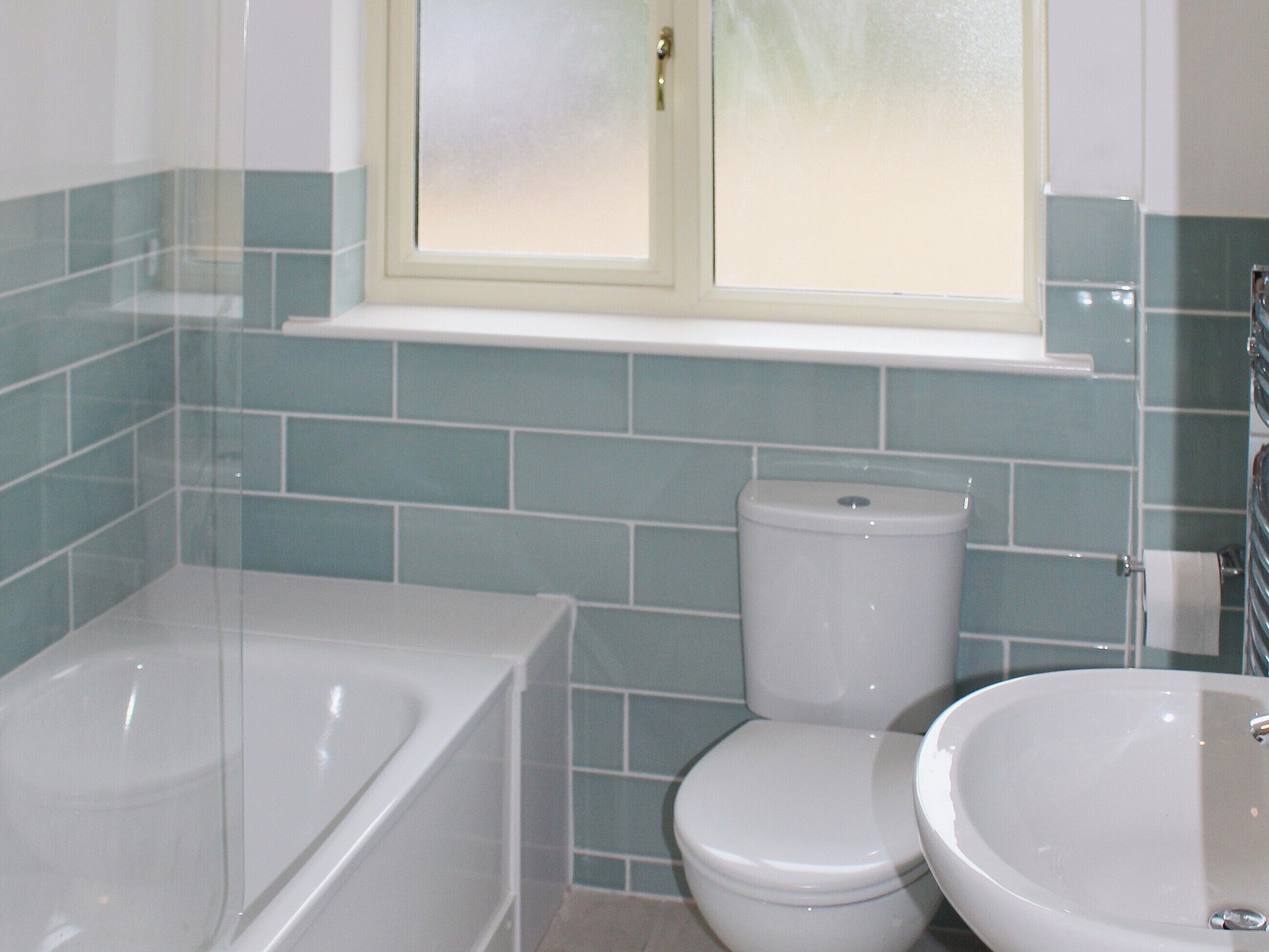 A bathroom with a bathtub, toilet, and sink.