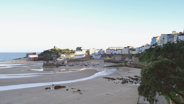 Une ville côtière dotée d ’une plage de sable, d’une jetée et de bâtiments qui bordent la côte.