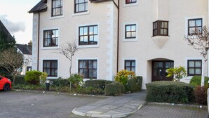 A multi-story building with a symmetrical facade, multiple windows, and a central entrance. - Bleaberry- Hewetson Court (Keswick)