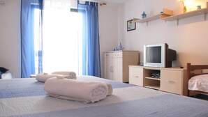 Ett hotellrum med en säng, en tv, ett skrivbord och en garderob.