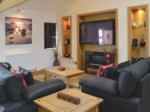 Ein Wohnzimmer mit Kamin, Flachbildfernseher und einem großen Gemälde.