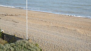 A pebbled beach with a flagpole and a flag. - 1 bedroom accommodation in Pevensey Bay (Pevensey Bay)