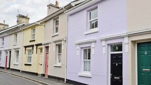 A row of terraced houses with distinct front doors, each with a different color. - 2 bedroom accommodation in Buckfastleigh (Buckfastleigh)