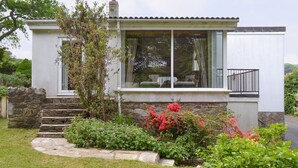 A modern house with a stone staircase leading to a glass door, surrounded by a well-maintained garden with various plants and flowers. - 3 bedroom accommodation in Constantine, near Falmouth (Constantine, near Falmouth)