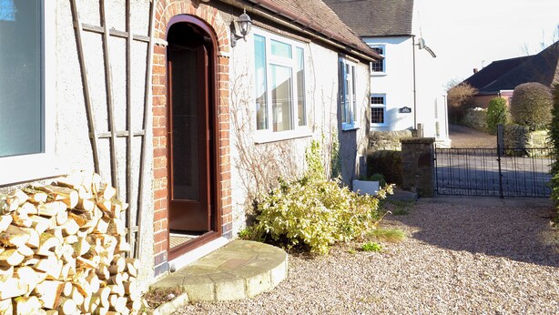 A house with a brick exterior, a wooden door, and a gravel driveway. - 2 bedroom accommodation in Pentrich, near Ripley (Pentrich, near Ripley)