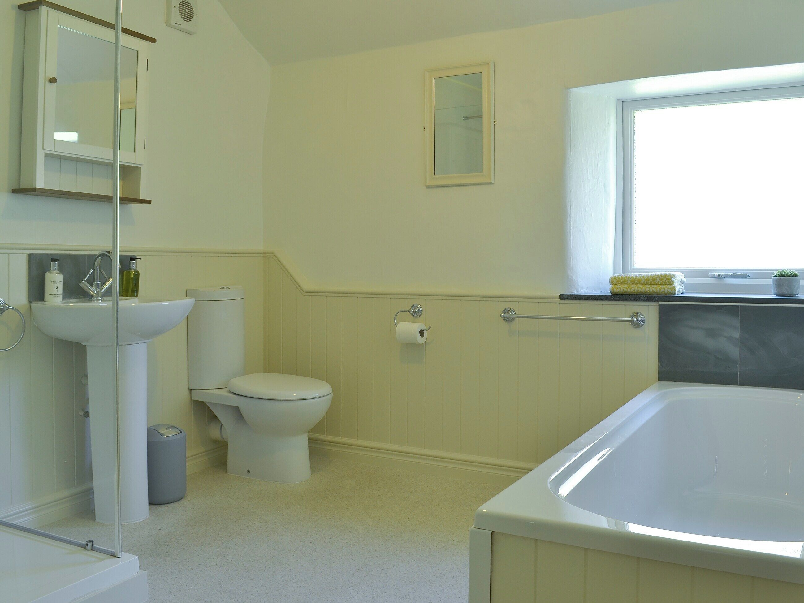 A bathroom with a toilet, sink, and bathtub.