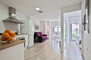 A modern apartment with a kitchen, dining area, and a living room with a sofa and a coffee table. - Chic Modern Flat Blanca 3 (Barcelona)
