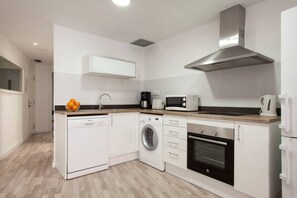 A compact kitchen with a dishwasher, washing machine, microwave, and oven. - Chic Modern Flat Blanca 3 (Barcelona)
