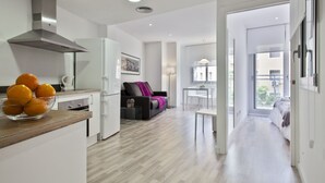 Een modern appartement met keuken, eethoek en woonkamer.