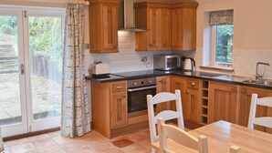A kitchen with wooden cabinets, a microwave, a toaster, and a sink. - 3 bedroom accommodation in Wiveton, near Cley next the Sea (Wiveton, near Cley next the Sea)
