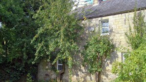 A stone building with ivy-covered walls and a grassy yard. - 5 bedroom accommodation in Byrness Village, near Otterburn (Byrness Village, near Otterburn)