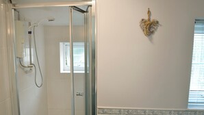 A bathroom with a glass-enclosed shower, a window, and a decorative wall piece. - 0 bedroom accommodation in Seatown (Seatown)