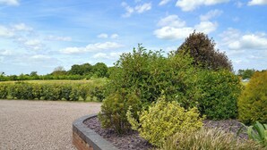 A landscaped garden with a gravel path and a brick border. - 3 bedroom accommodation in Burgh le Marsh, near Skegness (Burgh le Marsh, near Skegness)