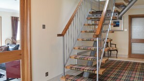 A staircase with wooden steps and metal railings, leading to an upper floor. - 4 bedroom accommodation in Tighnabruaich (Tighnabruaich)