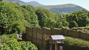 A wooden fence, a birdhouse, and a view of hills. - 2 bedroom accommodation in Portinscale, near Keswick (near Portinscale)