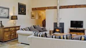 Una sala de estar acogedora con un sofá, un televisor, una chimenea y un armario de madera.