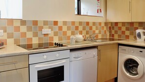 A kitchen with a stove, oven, dishwasher, and washing machine.
