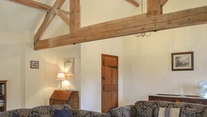 Una habitació amb dos sofàs estampats, una taula baixa de fusta, una làmpada i un quadre al mur.