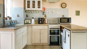 Eine Küche mit weißen Schränken, einer Mikrowelle, einem Herd und einem Toaster.