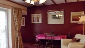 Una habitación con una mesa de comedor, sillas, una mesa redonda, un sofá y una lámpara.