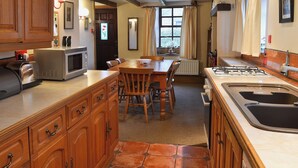 Une cuisine compacte avec des meubles en bois, une table à manger et une cuisinière intégrée.