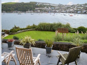 A patio with chairs and a signpost indicating amenities like the Willow Garden and Afternoon Cream Tea.
