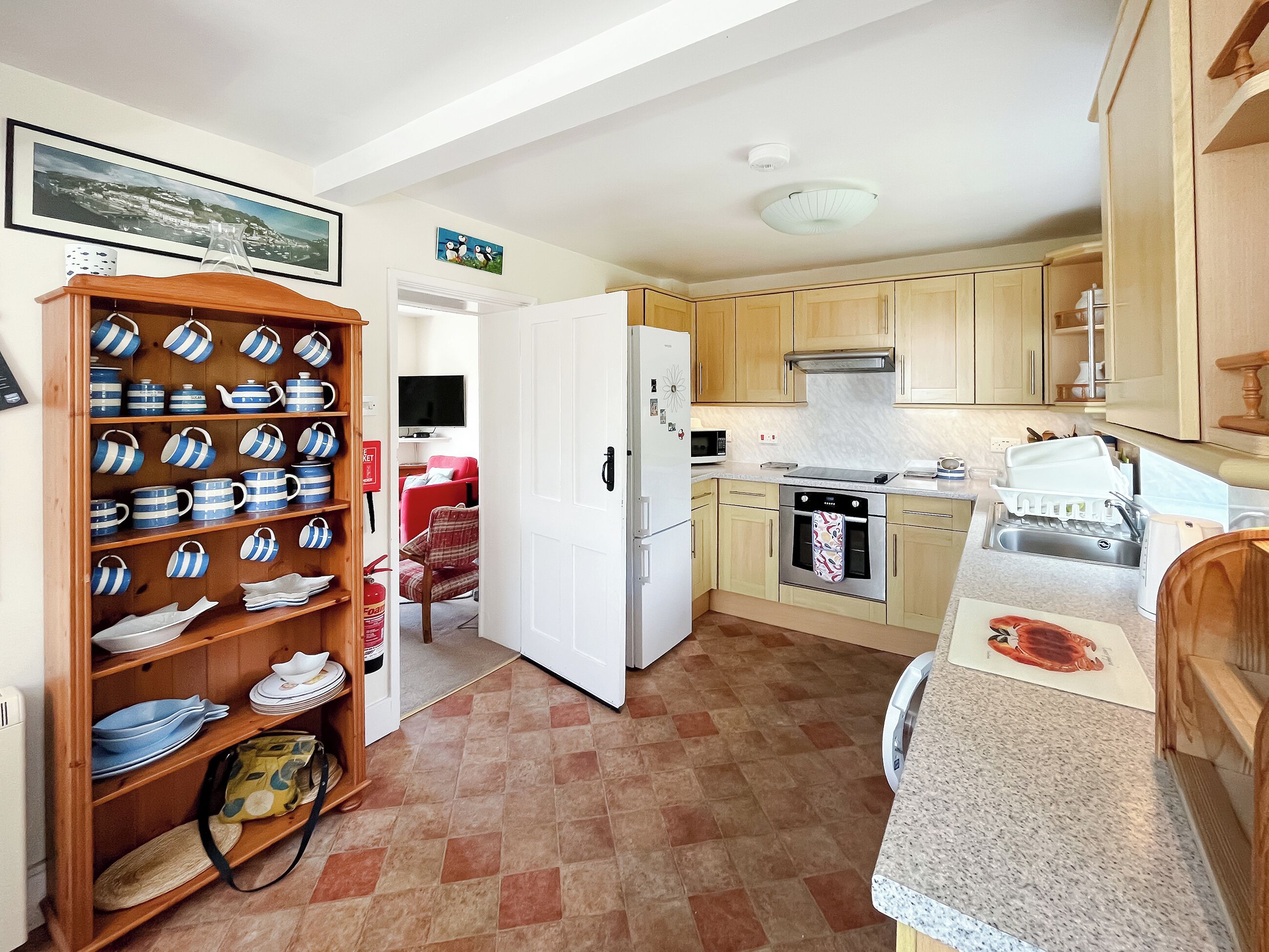 Una cocina compacta con armarios de madera, un refrigerador blanco, un microondas y una estufa.