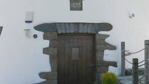 Un edificio con un arco de piedra y una puerta de madera, un letrero sobre la puerta que dice