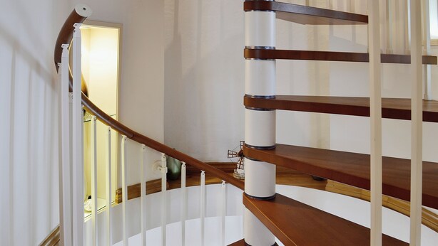 Una escalera de madera con barandillas y pasamanos blancos.