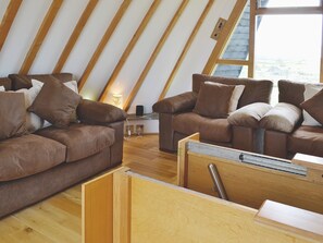 A cozy living room with brown leather sofas and wooden flooring. - 2 bedroom accommodation in Tynlon, near Rhosneigr (Tynlon, near Rhosneigr)