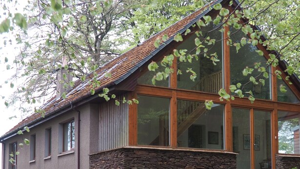 A modern house with a stone foundation, large windows, and a sloped roof. - 3 bedroom accommodation in Turriff (Turriff)