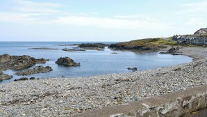 A rocky beach with houses in the background. - 3 bedroom accommodation in Turriff (Turriff)