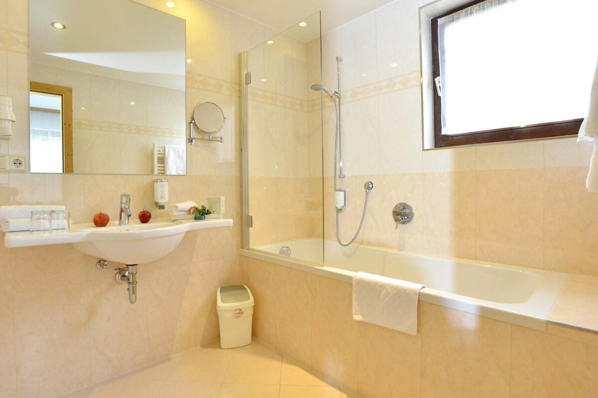 Un baño con lavabo, espejo, ducha y bañera.