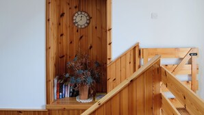 A wooden staircase with a clock on the wall above it. - 3 bedroom accommodation in John O’ Groats (John O’ Groats)