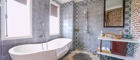 Un baño moderno con una bañera independiente, una zona de ducha y un tocador con espejo.