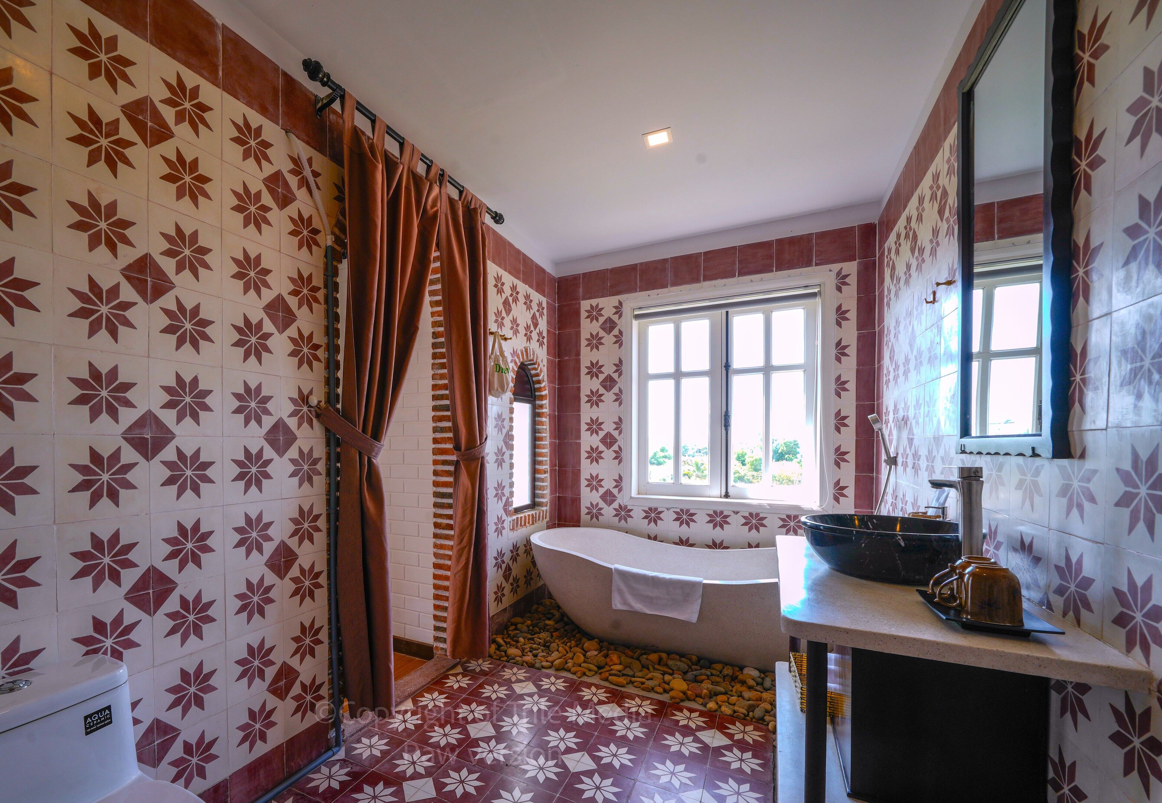 A bathroom with a bathtub, a window, and a sink with a mirror.