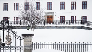 A white building with red-framed windows and a central wooden door. - Ulvhälls Herrgård (Strängnäs)