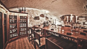 A rustic cellar with wooden furniture, wine bottles, and a bar area. - Ulvhälls Herrgård (Strängnäs)