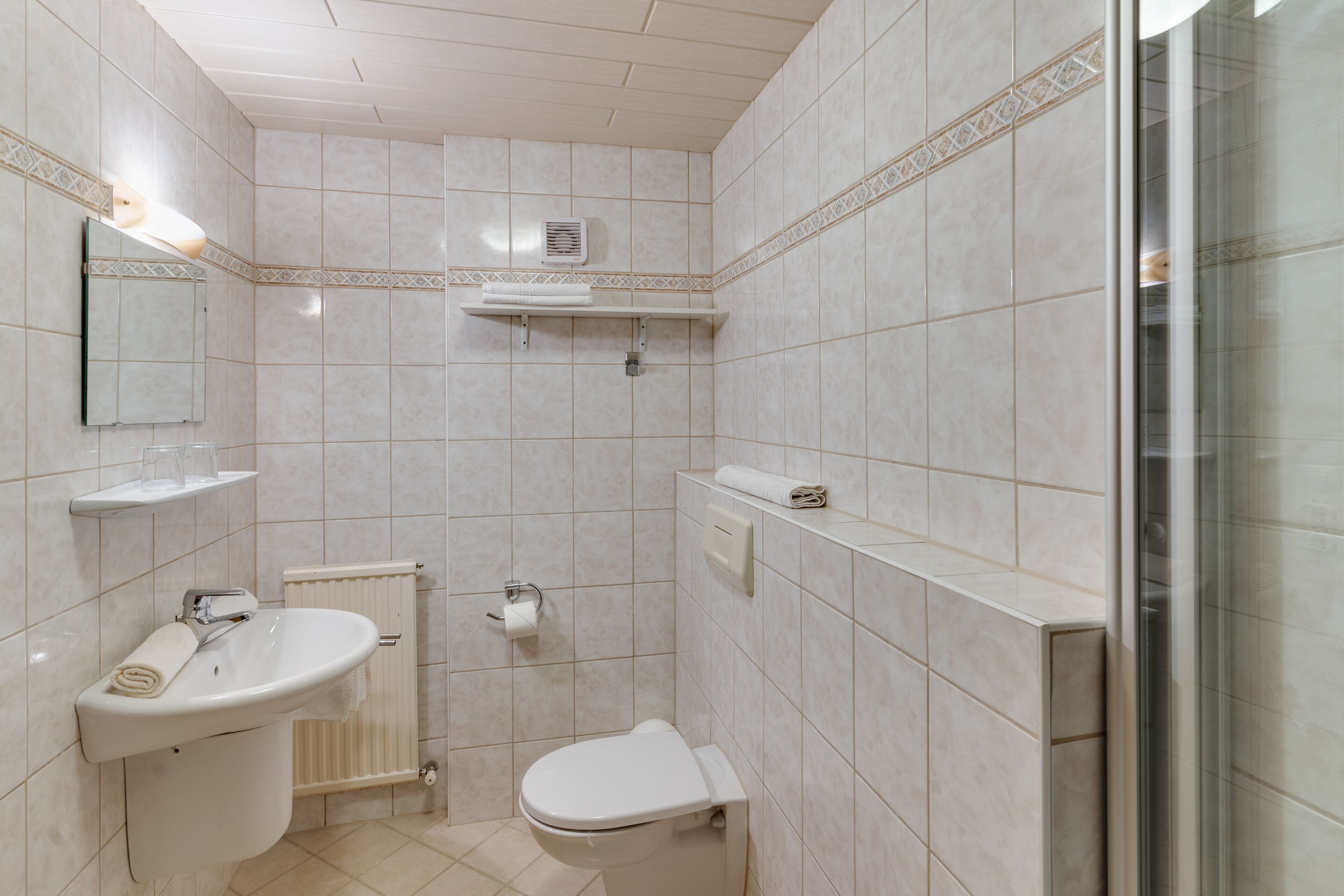 A bathroom with a toilet, sink, and shower.