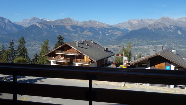 Eine Berglodge mit Balkon, einer Seilbahn und Blick auf die umliegenden Berge.