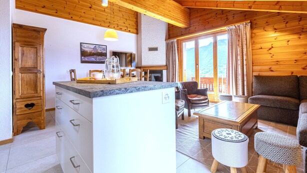 A cozy cabin interior with a kitchen, dining area, and living room.
